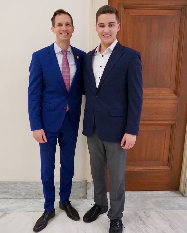 Aaron Prager standing beside Rep. Jake Auchincloss in front of a wooden door
